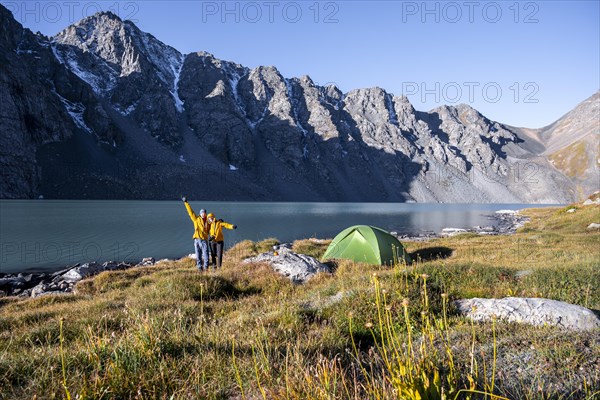 Two hikers camping in the wilderness, mountain lake in the Tien Shan, Lake Ala-Kul, Kyrgyzstan, Asia