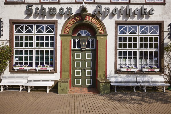 Entrance door of the Swan pharmacy with windows, flower boxes and benches in the city centre of Husum, Nordfriesland district, Schleswig-Holstein, Germany, Europe