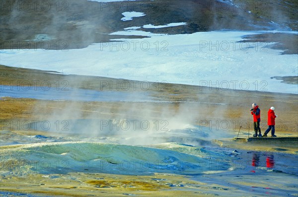 People standing in a winter landscape in front of a steaming mud spring, Namafjall, Myvatn, Iceland, Europe