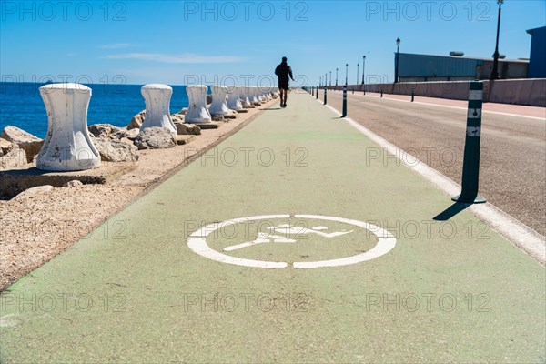 Moll de Llevant waterfront promenade, a 4.5 km long promenade for joggers, walkers, cyclists and skaters at the harbour of Tarragona, Spain, Europe