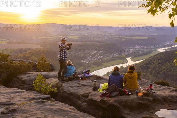 Sunrise on the Lilienstein. The Lilienstein is the most striking and best-known rock in the Elbe Sandstone Mountains. View of the Elbe valley towards Bad Schandau. Tourists enjoy a sunrise breakfast high above the Elbe, Ebenheit, Saxony, Germany, Europe