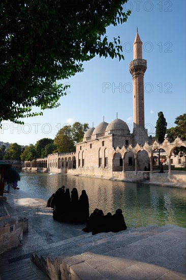 Muslim women wearing abaya in front of Abraham's Pool where the prophet was thrown into fire by King Nimrod, Sanliurfa, Turkey, Asia