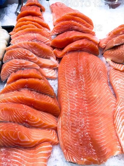 Display of Pacific salmon (Oncorhynchus) caught by fishing in the form of salmon fillet on ice in refrigerated counter Fish counter of fishmonger Fish retail, food trade, wholesale, fish trade, speciality shop, Germany, Europe