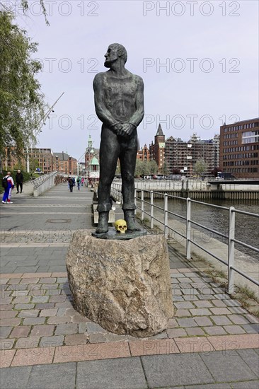 Stoertebecker sculpture on Stoertebecker Ufer, Elbtorpromenade, Hafencity, Hamburg, Sculpture of a man on a stone pedestal in front of a river landscape in the city, Hamburg, Hanseatic City of Hamburg, Germany, Europe