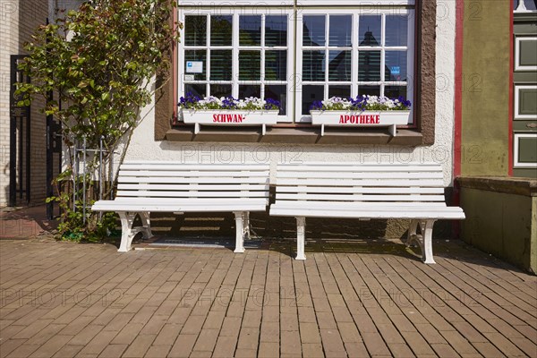 Benches and windows with flower boxes at the Swan pharmacy in the city centre of Husum, Nordfriesland district, Schleswig-Holstein, Germany, Europe