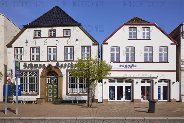 Swan pharmacy with bus stop Rathausplatz and a residential and commercial building from the 18th century in Husum, Nordfriesland district, Schleswig-Holstein, Germany, Europe