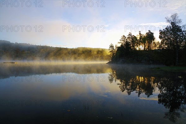 Autumn morning mist over a calm lake, foliage colouring, Bullaren, Bohuslaen. Sweden