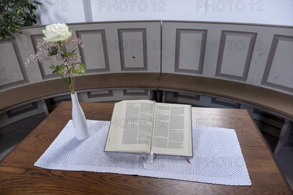 Open Bible next to a vase of flowers with a white Rose in the Protestant Reformed Church from 1401 in Greetsiel, Krummhoern, East Frisia, Lower Saxony, Germany, Europe