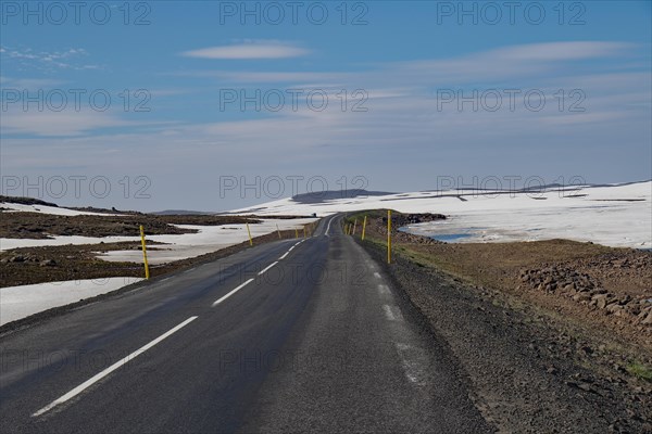 Road leads through barren mountain landscape with snow and ice, Seydisfjoerdur, Fjaroarheioi, Iceland, Europe