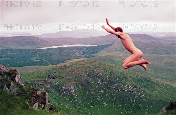 Naked man jumping in front of mountain scenery, Connemara National Park, Republic of Ireland, 20 July 1993, vintage, retro, old, historical, funny