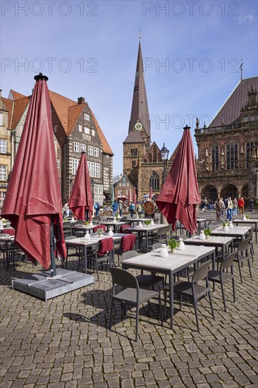 Outdoor area of a restaurant with red parasols and the Church of Our Lady on the market square in Bremen, Hanseatic City, State of Bremen, Germany, Europe
