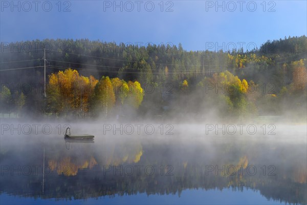 Autumn morning mist over a calm lake, foliage colouring, Bullaren, Bohuslaen. Sweden