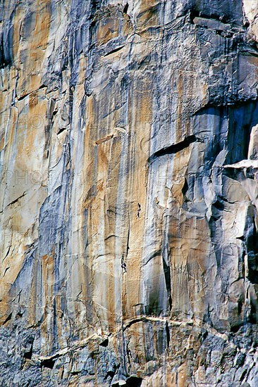 Rock face with climber, Canyon de Chelly National Monument, area of the Navajo Nation in the north-east of the US state of Arizona. The nearest town is Chinle. Colorado Plateau, Arizona, USA, North America