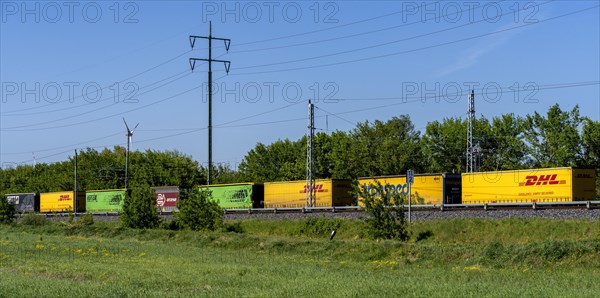 Goods train on a railway line in the landscape of Berlin-Beech, Germany, Europe