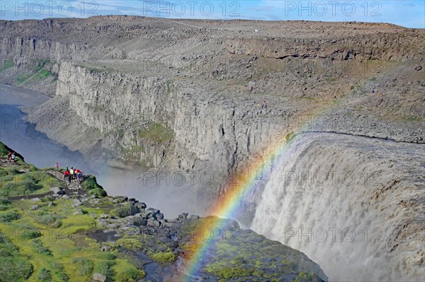Group of people in front of waterfall, rainbow, barren landscape, Dettifoss, vatnajoekull National Park, Iceland, Europe