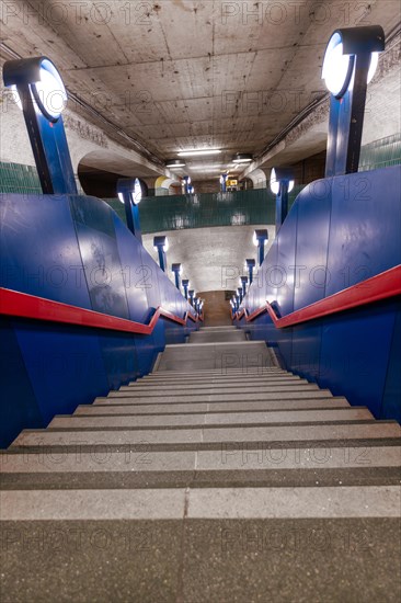 An empty staircase down to a Schloss Strasse underground station with characteristic blue colour scheme and lighting, Berlin, Germany, Europe