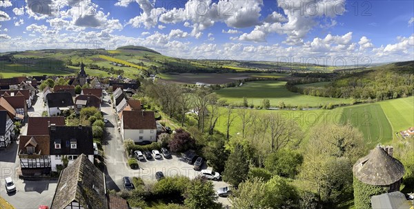 View from large castle tower tower of 13th century castle today castle hotel Trendelburg to village Trendelburg with old village church in the background, fields in spring on the right, small castle tower at the bottom right of the picture, Weserbergland, Hesse, GermanyTrendelburg, Weserbergland, Hesse, Germany, Europe