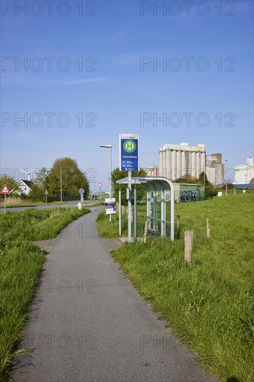 Bus stop Fischersiedlung with cycle path and silos in the harbour of Husum, district of Nordfriesland, Schleswig-Holstein, Germany, Europe