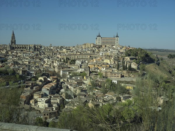 Historic city with river and numerous buildings, surrounded by hills, striking church towers, all under a clear blue sky, historic city with old houses and large churches on a small river in front of a blue sky, toledo, spain