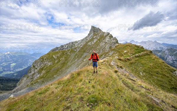 Mountaineer at Schoenjochl, mountain landscape at the ridge with green meadows, Obergailtal, Carnic main ridge, Carnic Alps, Carinthia, Austria, Europe