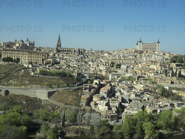 Historic old town with a river landscape and striking church towers, framed by hills, under a clear blue sky, historic town with old houses and large churches on a small river in front of a blue sky, toledo, spain