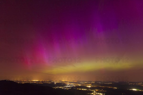 Northern lights in Germany. Very strong auroras over the Stuttgart metropolitan region. View from Breitenfels near Ochsenwang on the Swabian Alb, 10.05.2024. View towards Stuttgart, Teck Castle in the foreground