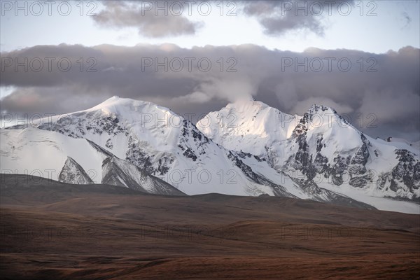 Glaciated and snow-covered mountains, autumnal plateau with yellow grass, Tian Shan, Sky Mountains, Sary Jaz Valley, Kyrgyzstan, Asia