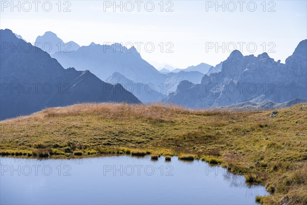 Mountain lake in front of mountain landscape, silhouettes of rocky mountain peaks, Luggauer Toerl, Carnic High Trail, Carnic Main Ridge, Carnic Alps, Carinthia, Austria, Europe