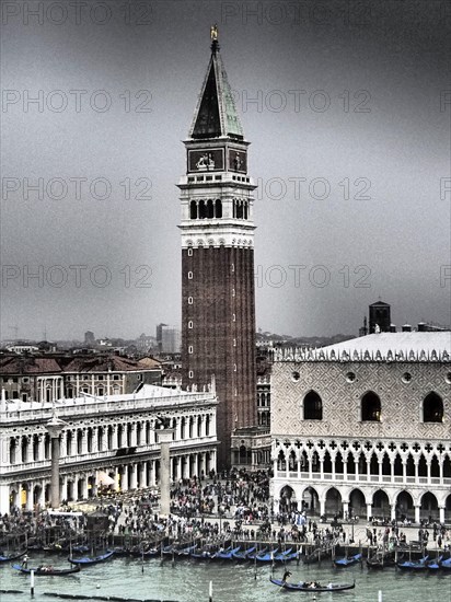 A view of the Campanile and St Mark's Square in Venice, with gondolas and historic buildings on a cloudy day, church towers and historic buildings on a large canal, view of Venice from the water, Venice, Italy, Europe