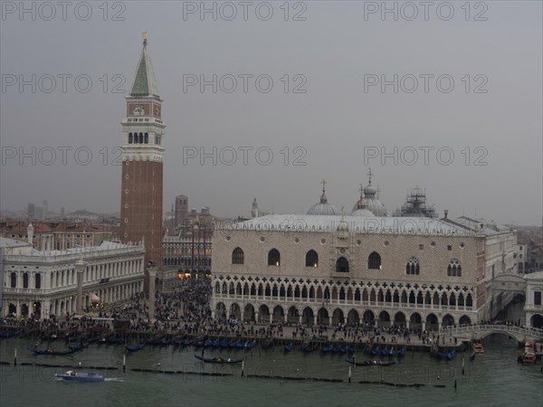 St Mark's Square in Venice with the Campanile and historic buildings, surrounded by water in a misty atmosphere, church towers and historic buildings on a large canal, view of Venice from the water, Venice, Italy, Europe