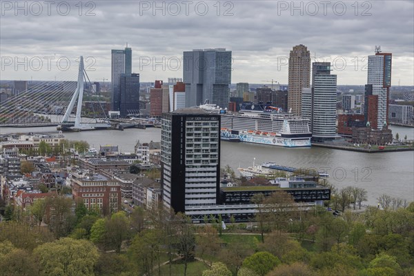 City view with prominent skyscraper skyline, river, cruise ship and modern bridge under a cloudy sky, modern houses and a bridge with a river from above, Rotterdam, Netherlands
