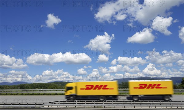 A DHL lorry drives past Deggendorf on the A3 motorway, with the Bavarian Forest in the background, Bavaria, Germany, Europe