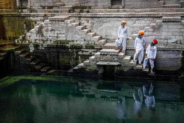 Three traditional men with turban at the steps at the stepwell Toorji Ka Jhalra in Jodhpur, Rajasthan, India, Asia