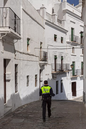 Policeman walking through a small alley, Vejer, Andalusia, Spain, Europe