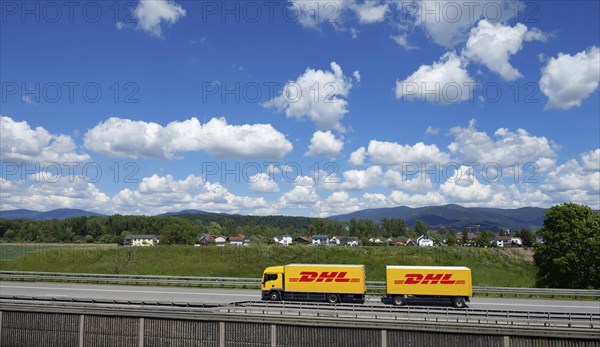 A DHL lorry drives past Deggendorf on the A3 motorway, with the Bavarian Forest in the background, Bavaria, Germany, Europe