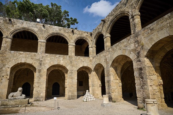 Courtyard of a medieval fortress under a blue sky, surrounded by trees with lion statue, outdoor area, Archaeological Museum, Old Town, Rhodes Town, Rhodes, Dodecanese, Greek Islands, Greece, Europe