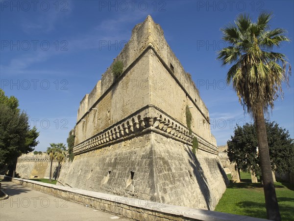 Old fortress wall with trees and green area under the blue sky on a sunny day, The city of Bari on the Mediterranean Sea with historic buildings, small boats in the harbour and beautiful churches and the old fortress, bari, italy