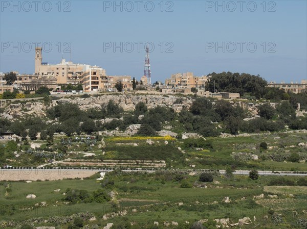 Overview of a town with various buildings, green areas and a striking tower in the background, the town of mdina on the island of malta with historic houses, colourful balconies, magnificent churches, mdina, Malta, Europe