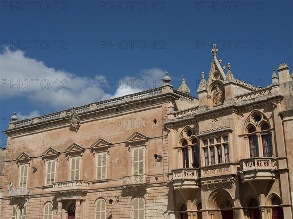 A historic building with gothic windows and blue sky in the background, the town of mdina on the island of malta with historic houses, colourful balconies, magnificent churches, mdina, Malta, Europe