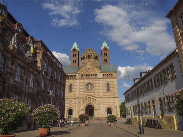 View of a cathedral with gothic towers and surrounding historical buildings under a blue sky, large cathedral with two towers in front of blue sky with clouds, Speyer, Germany, Europe