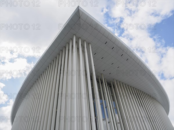 Close-up of a modern building in Luxembourg with vertical columns and blue sky in the background, modern buildings with trees and glass facades, luxembourg