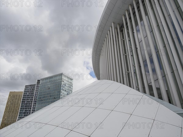 White dome and modern glass buildings in Luxembourg under a cloudy sky, modern buildings with trees and glass facades, luxembourg