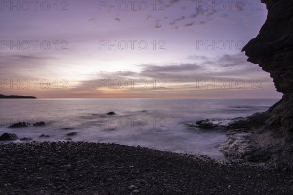 Sunrise with sea view in a lonely bay. rocky coast in warm colours. Landscape with a lava stone beach of Tarajalejo on Fuerteventura, Canary Islands, Spain, Europe