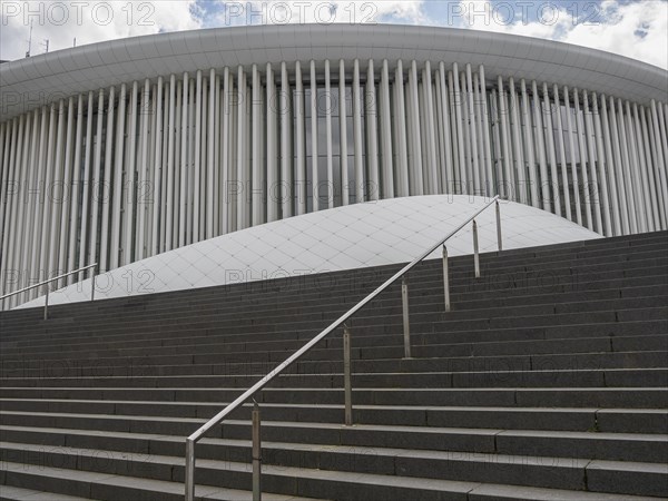 Cantilevered columns and curved shapes characterise the architecture of a modern building in Luxembourg, modern buildings with treetops and glass facades, luxembourg