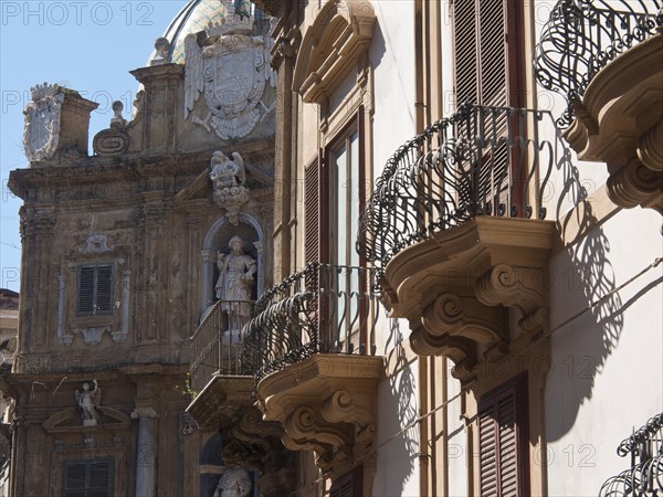 Close-up of balconies and sculptures on a baroque facade, palermo in sicily with an impressive cathedral, monuments and old houses with balconies, palm trees and flowers in italy, palermo, sicily