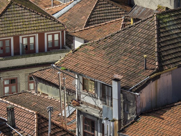 Close-up of old buildings with red tiled roofs and balconies giving a weathered, charming atmosphere, old town with historic houses and red roofs in poertugal, porto, portugal