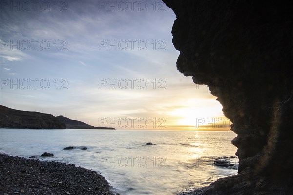 Sunrise with sea view in a lonely bay. rocky coast in warm colours. Landscape with a lava stone beach of Tarajalejo on Fuerteventura, Canary Islands, Spain, Europe