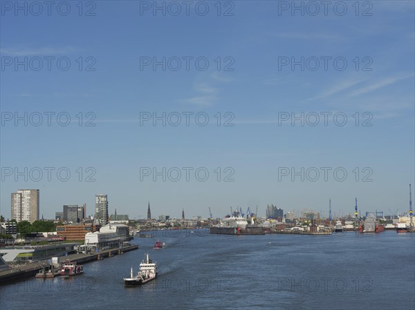 Panoramic view of an urban harbour landscape with boats and cranes under a blue sky, a picturesque city on the river with harbour, shipyards, houses and ships, Hamburg, Germany, Europe