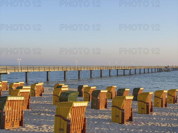 Beach chairs at a pier on the beach at sunset, quiet atmosphere, autumn atmosphere on the beach of Binz with trees beach chairs in the morning light, Binz, germany