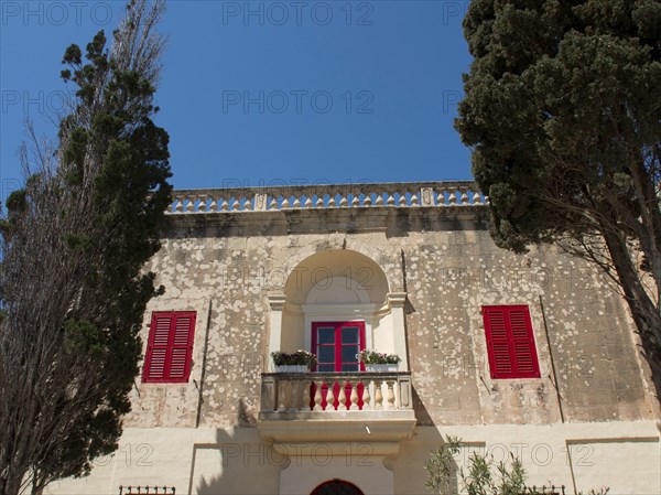 Buildings with red shutters and stone balconies, surrounded by trees, the town of mdina on the island of malta with historic houses, colourful balconies, magnificent churches, mdina, Malta, Europe